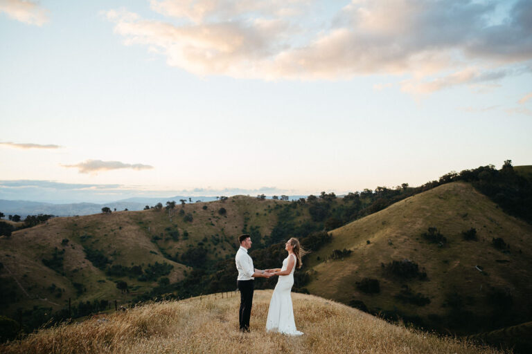 a wedding couple stand on the top of a mountain in country victoria in alexandria