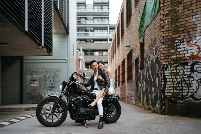 Photographer Jason Lau's wedding to musician Annette, couple sit on motorbike in a Melbourne laneway