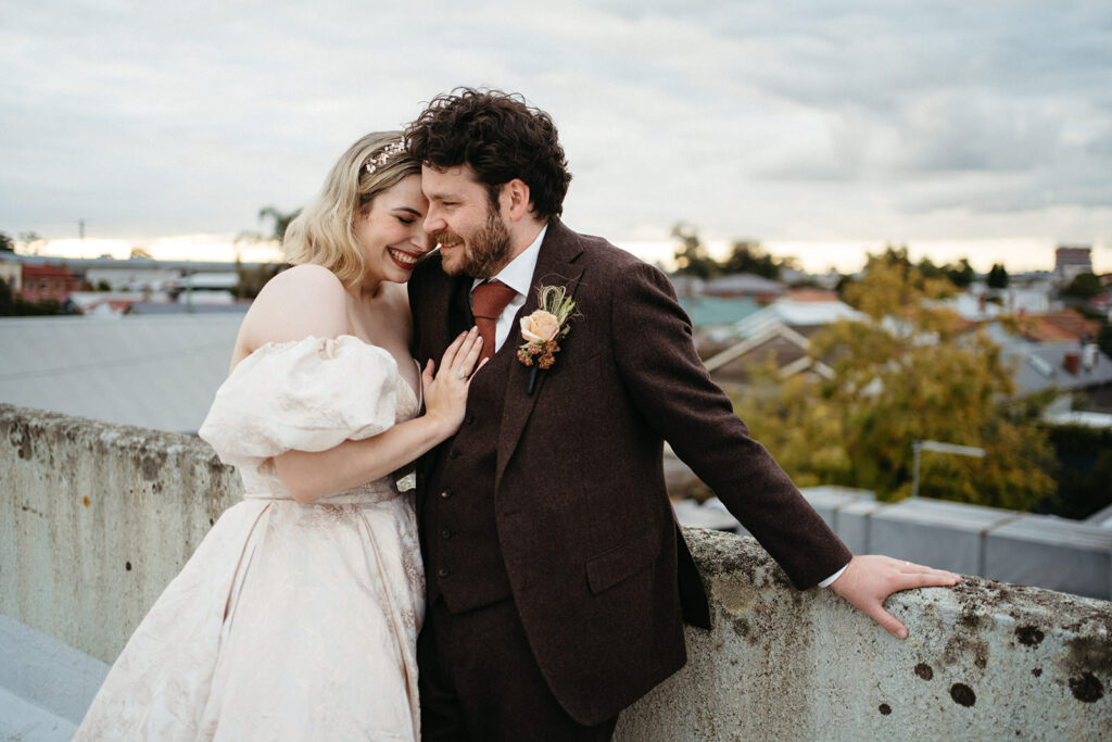 a bride leans into her groom on a rooftop in Melbourne