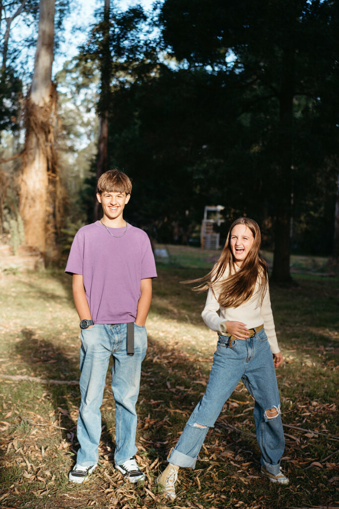 two siblings have fun together the boy wears a purple shirt, they are in high contrast light