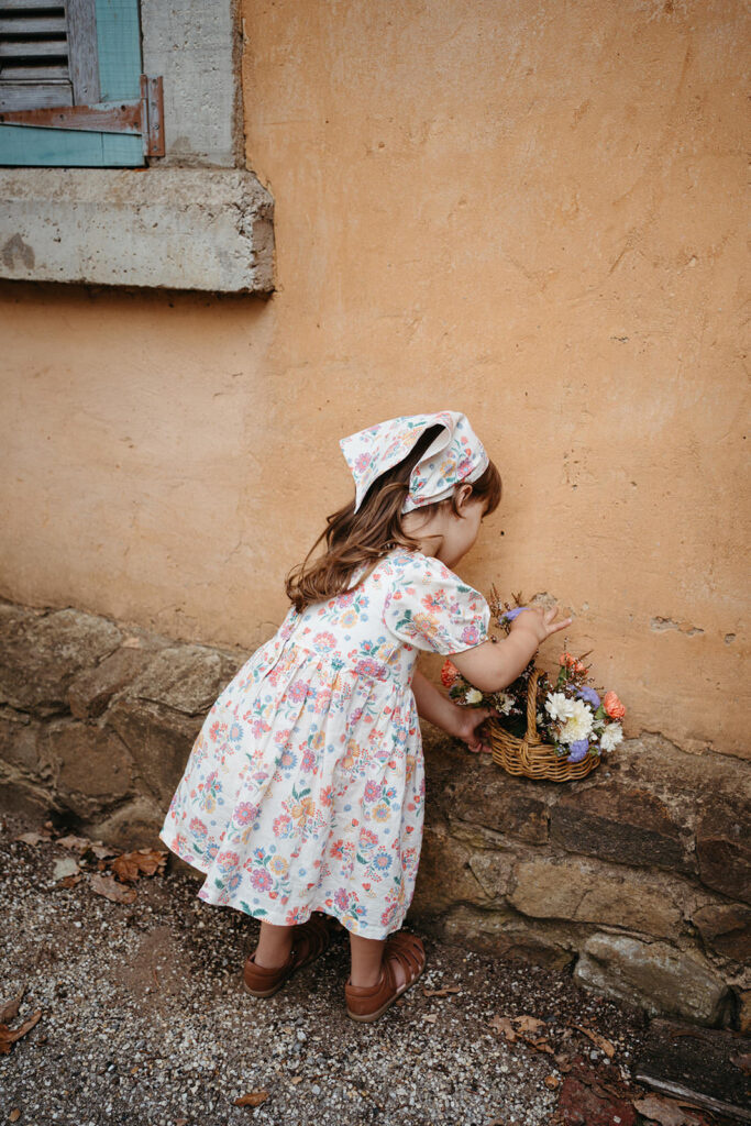 a girl in a floral dress picks flowers kids clothing brand