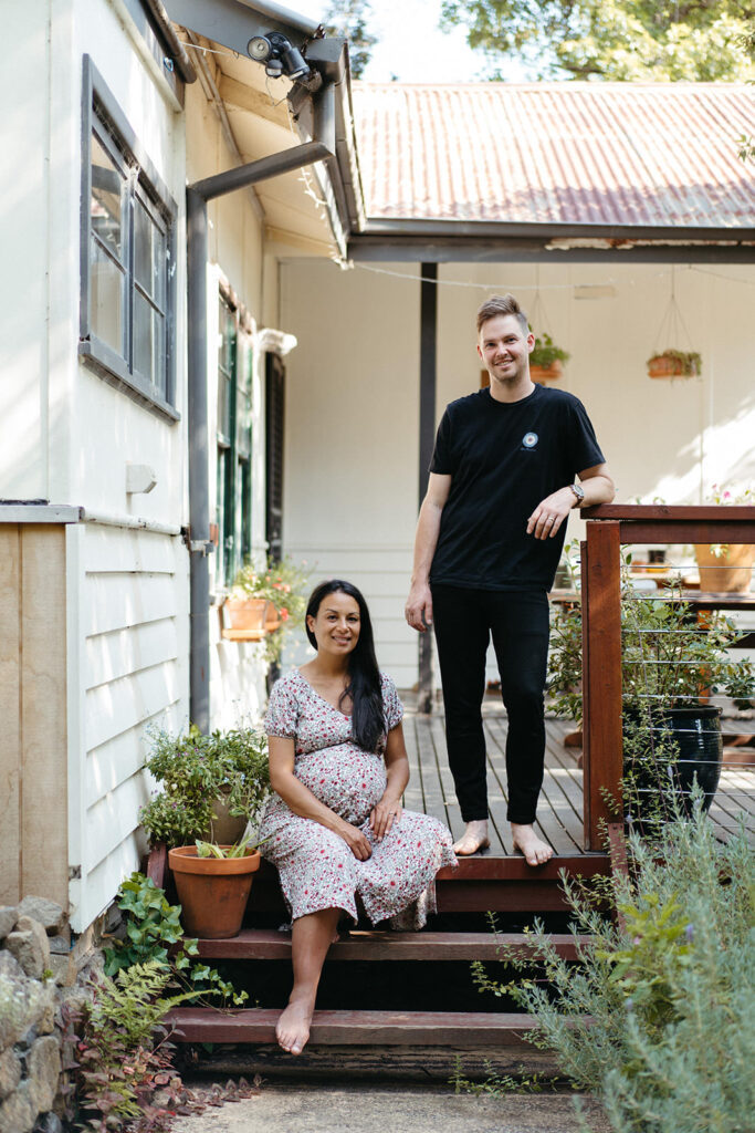 Pregnancy couple on porch in Melbourne the woman is sitting