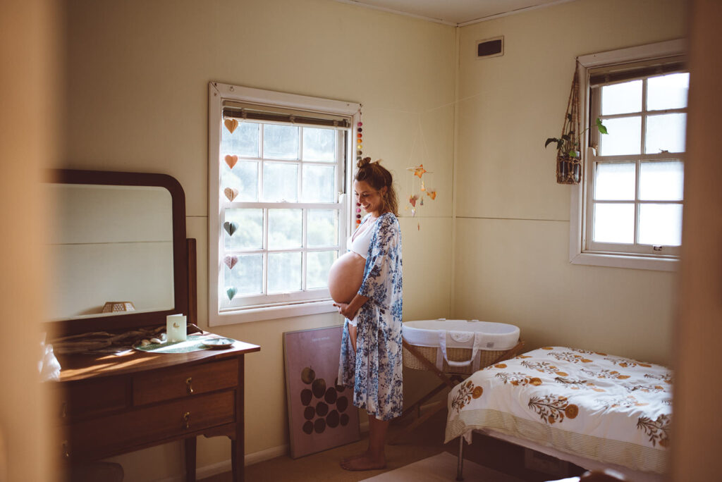 maternity photo of a mother in a nursery